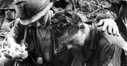 Two American soldiers in Vietnam, one comforting the other, black & white image